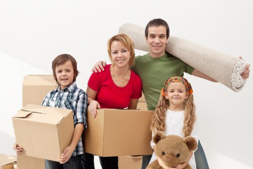Professional removals service preparing furniture for transport in a Merton home
